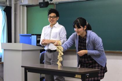 どこまで積み上げられるかな？講師の岡田先生が見守る中、学生も真剣な表情で取り組みます。