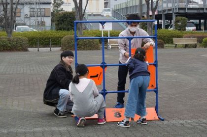 ストラックアウトコーナーで子どもたちと一緒に組み立てる学生たち